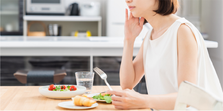 食事中に右顎を触る女性