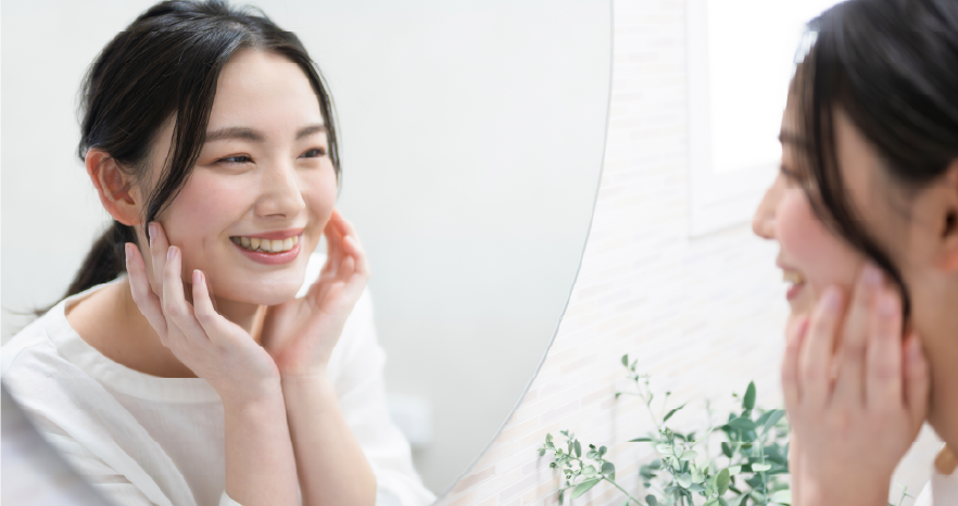 鏡を見て微笑んでいる女性
