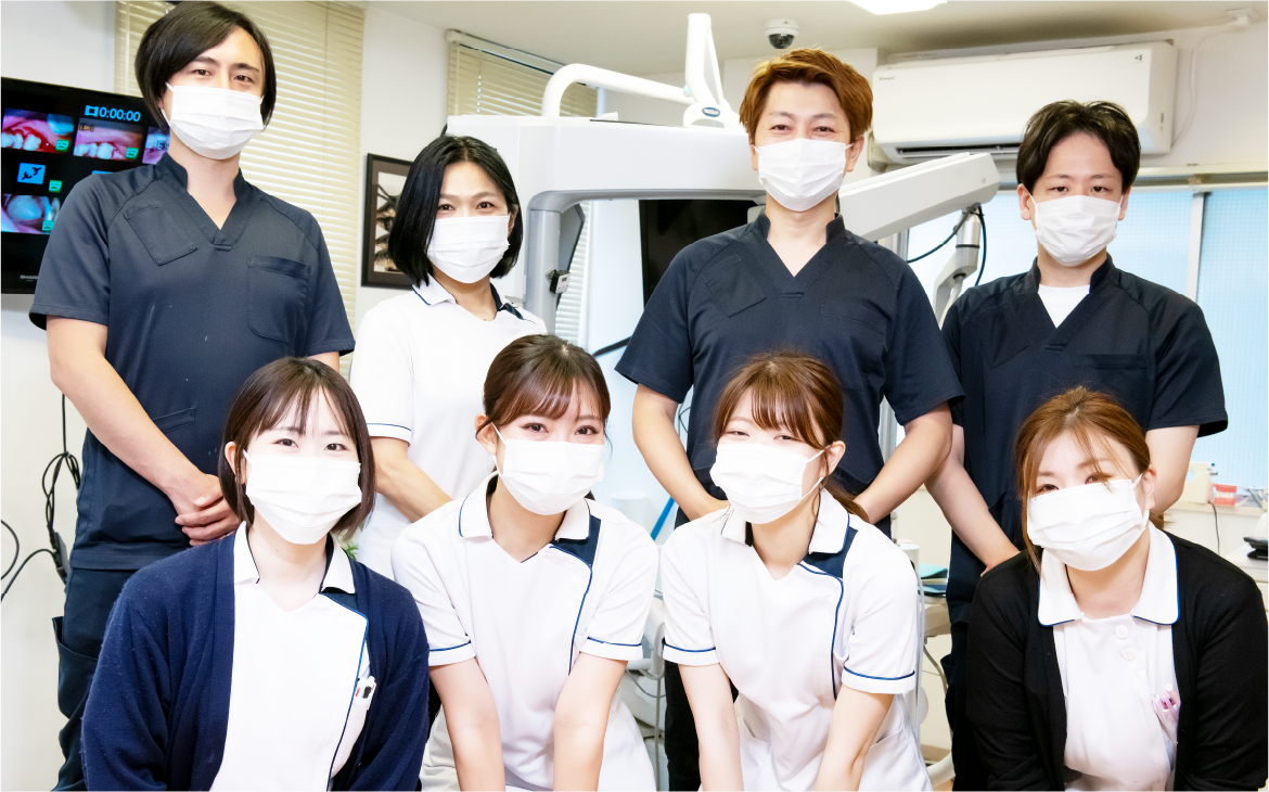 マスクを着けた歯科医師とスタッフが並んで撮影した集合写真